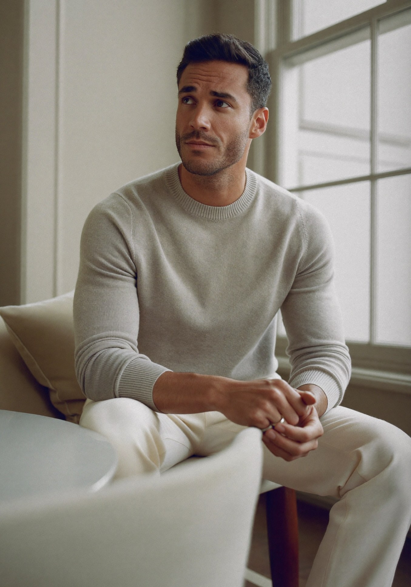 A composed, thoughtful man in a quiet, refined interior, considering a private decision