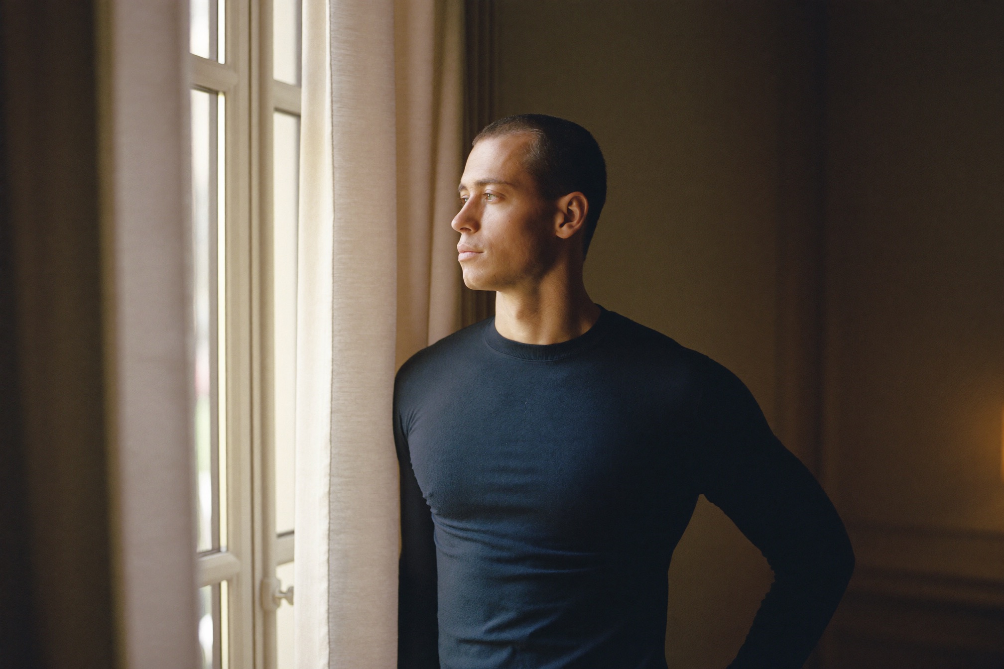 A composed man at a window, calm and at ease